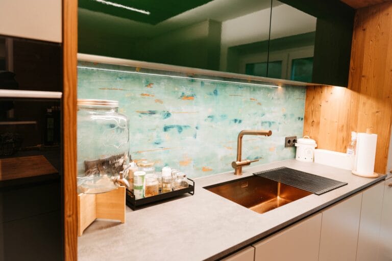 Küchenzeile mit bedruckter Glasrückwand und Kupferspülbecken
