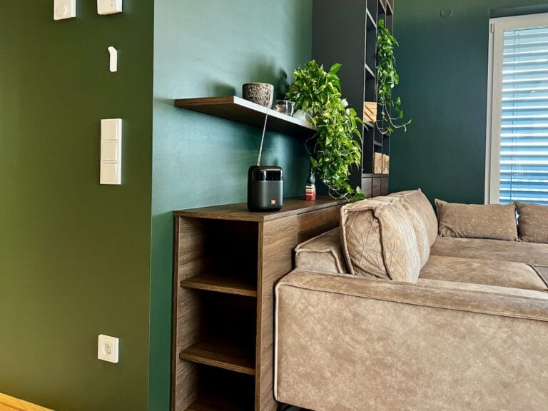 Sofa mit Einbauregal vor farbiger Wand