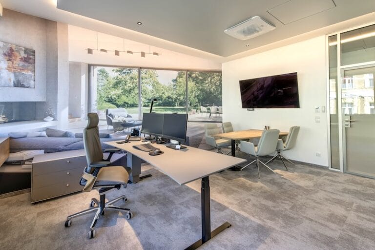 Chefbüro mit Fototapete, Besprechungstisch, Wandbildschirm und großem Schreibtisch