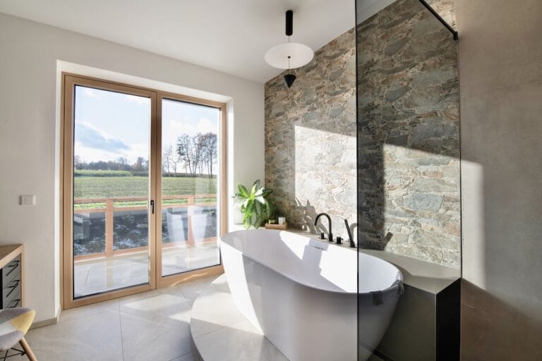 Badezimmer mit freistehender Badewanne und Ausblick