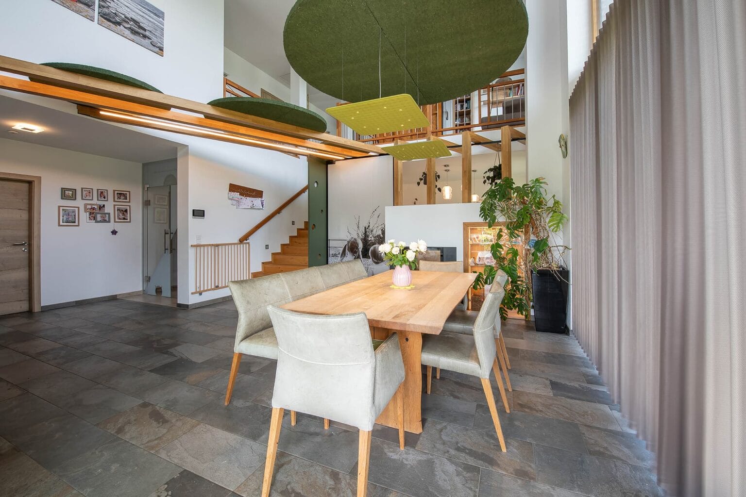 Kreative Raumtrennung und Akustiklösung von Horst Steiner Innenarchitektur für Wohn-/Esszimmer mit Galerie.