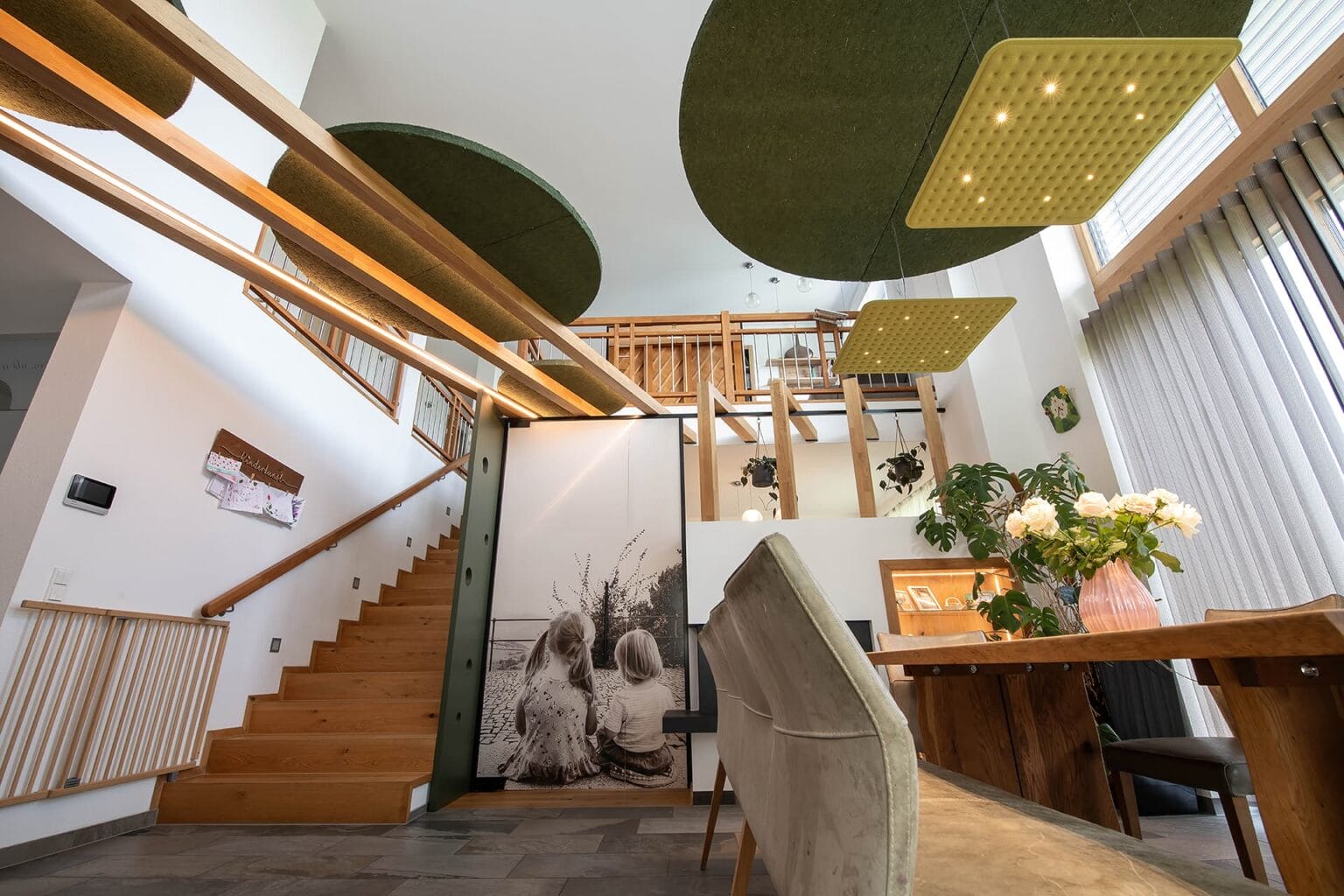 Kreative Raumtrennung und Akustiklösung von Horst Steiner Innenarchitektur für Wohn-/Esszimmer mit Galerie.