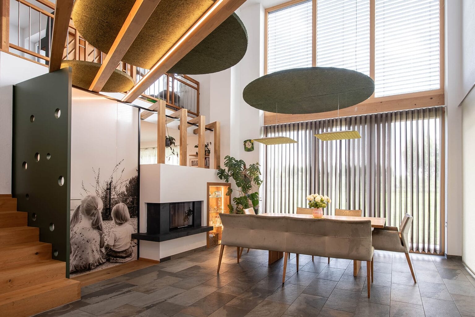 Kreative Raumtrennung und Akustiklösung von Horst Steiner Innenarchitektur für Wohn-/Esszimmer mit Galerie.