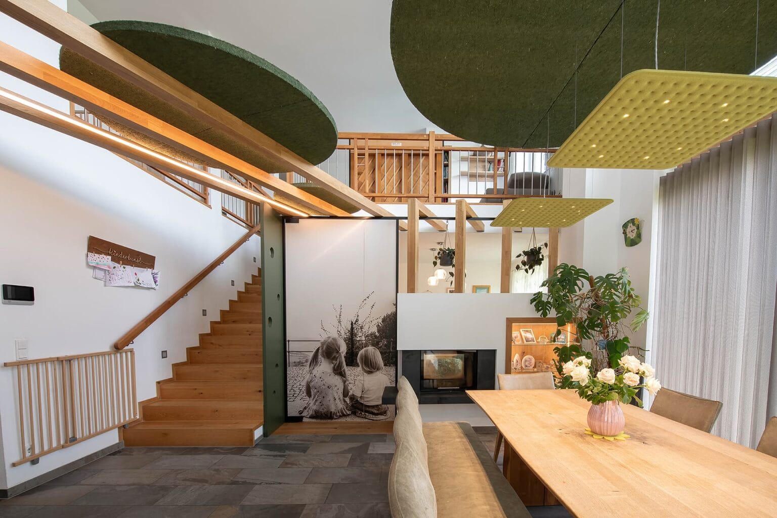 Kreative Raumtrennung und Akustiklösung von Horst Steiner Innenarchitektur für Wohn-/Esszimmer mit Galerie.